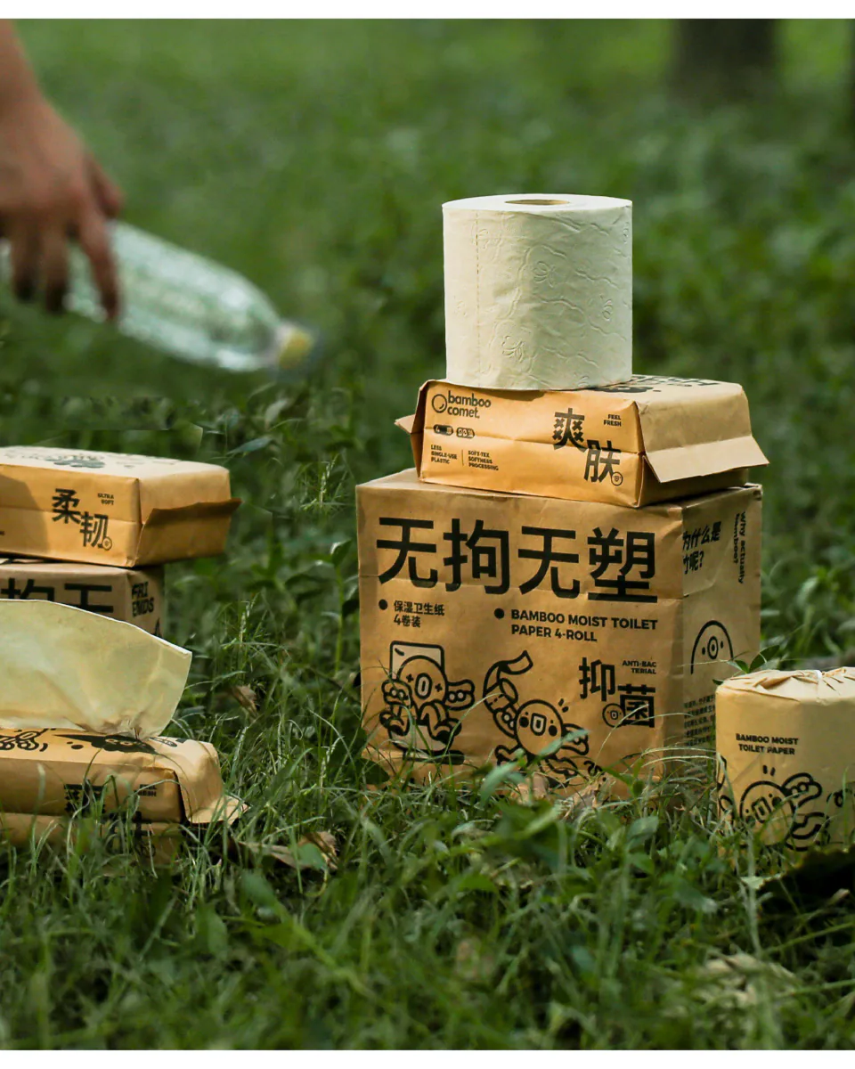 草地上陈列的 BambooComet 纸巾包装、卷纸与纸巾盒