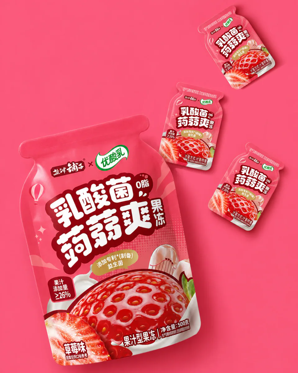 粉色背景中陈列的优酸乳联名蒟蒻爽草莓味大袋、小袋与吸吸袋包装