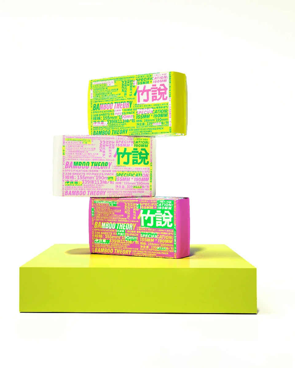 白色背景与绿色台面上完整堆叠展示的竹说彩色纸品包装