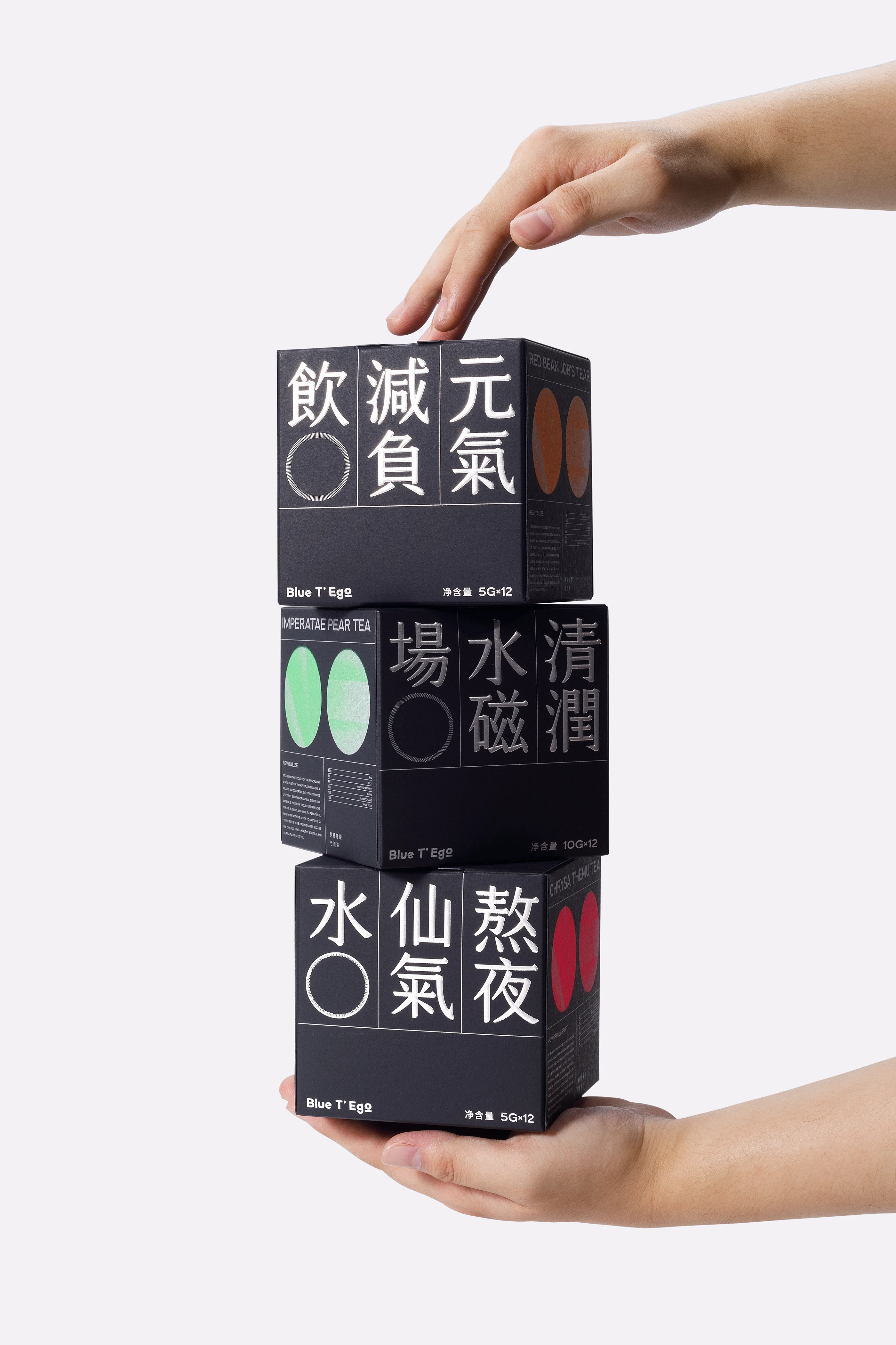 两只手托起三款 Blue T’Ego 黑色袋泡茶盒装的组合展示