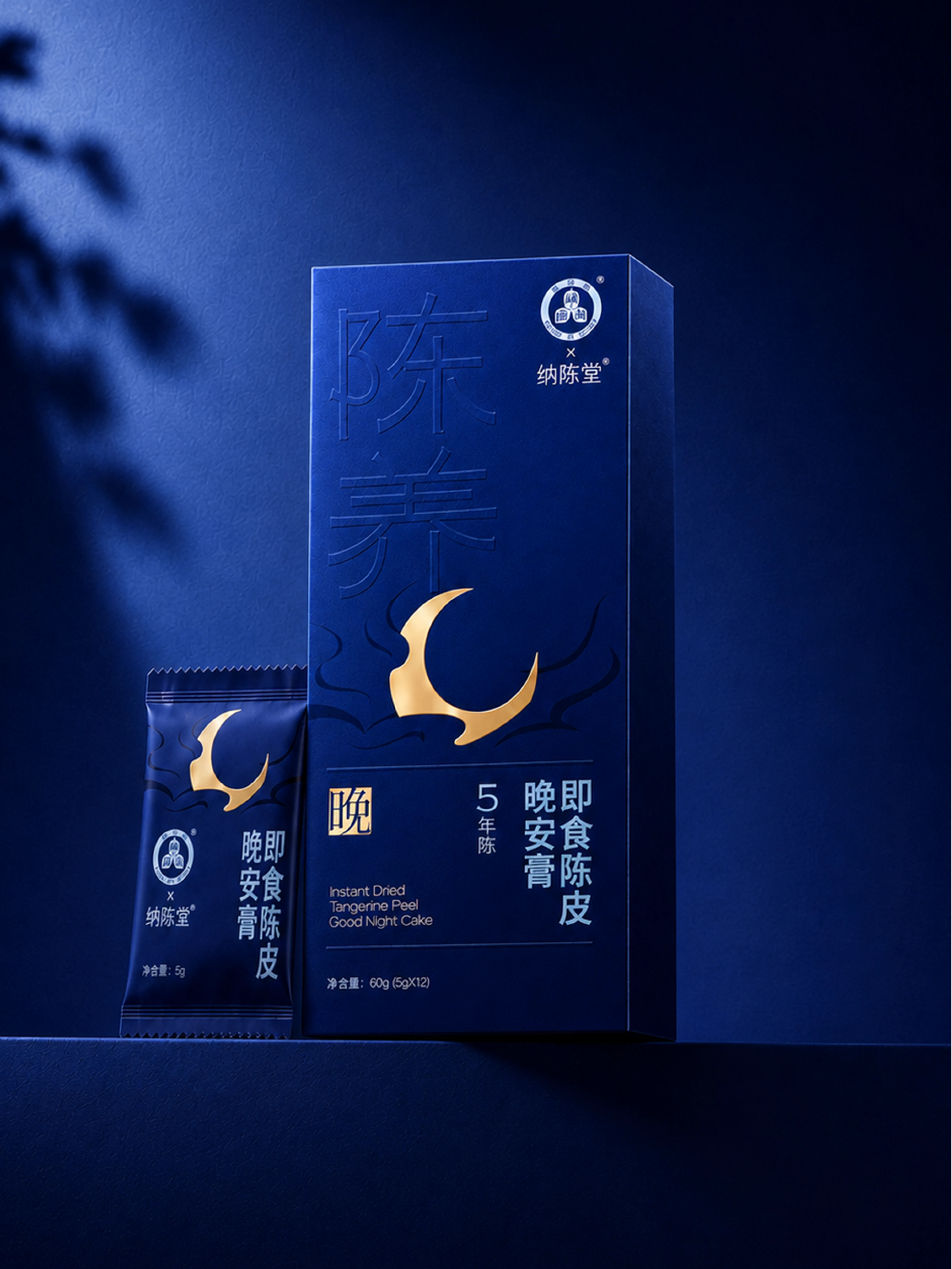 深蓝背景中的晚安膏陈皮膏礼盒与单条装,盒面有金色月牙和流动祥云